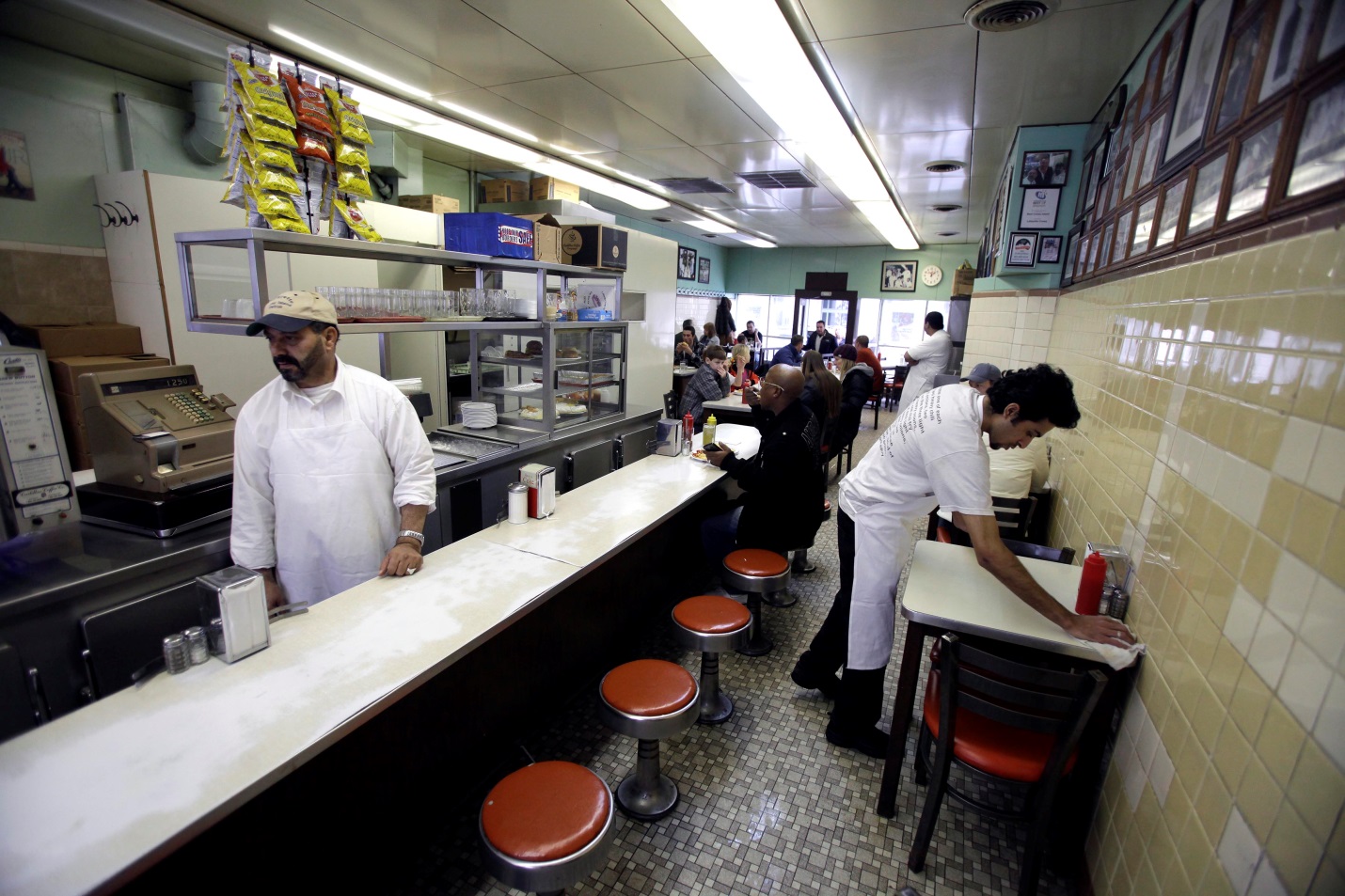A waiter clears a table at Lafayette Coney Island restaurant in Detroit, Michigan, February 24, 2013. Photo: J.D. Pooley / Getty Images