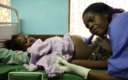 Nurse Melifa Mphasa listens to the pregnant belly of her patient in the labor ward at Bwalia 'Bottom' Hospital in Lilongwe, Malawi. Photo: Abbie Trayler-Smith / Oxfam