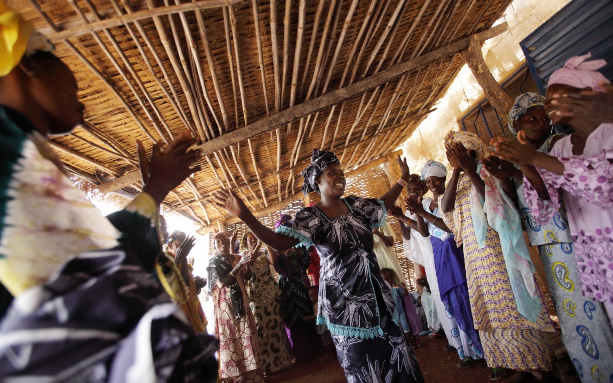Women from the village of Bandafassi, Senegal celebrate following a Saving for Change meeting. Aminata Barry (center) used group support to create an embroidery business. Photo: Rebecca Blackwell / Oxfam America