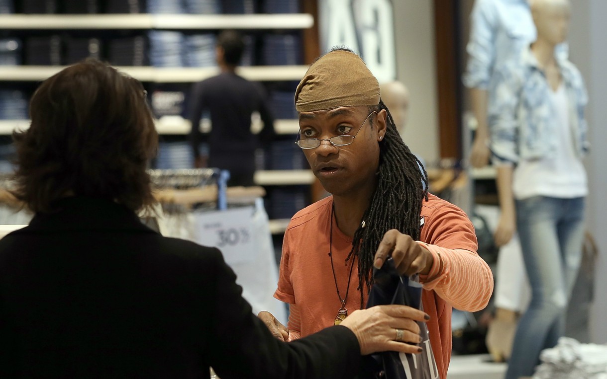 Gap employee Ni’Jean Gibson helps a customer in February 2014 in San Francisco. Gap Inc. announced that it will raise its hourly minimum wage for US employees to $9 in June 2014 and to $10 by June 2015. Photo: Justin Sullivan / Getty Images